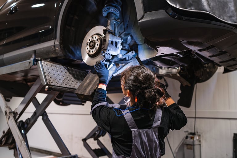 Female mechanic working under car