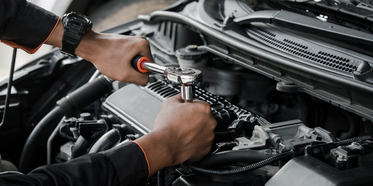 Mechanic fixing car at home